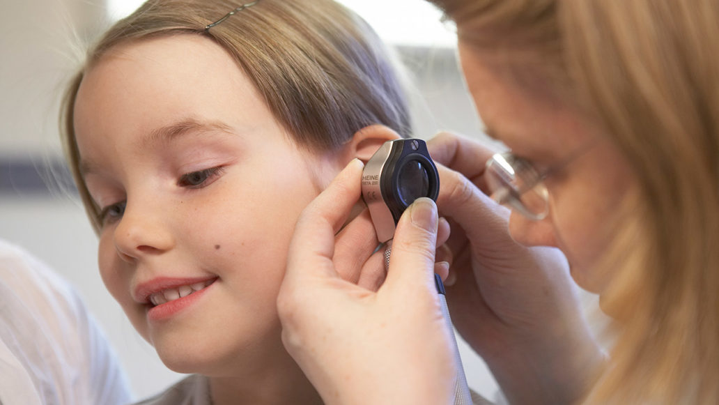 A doctor looking into a child’s ear with an instrument. 