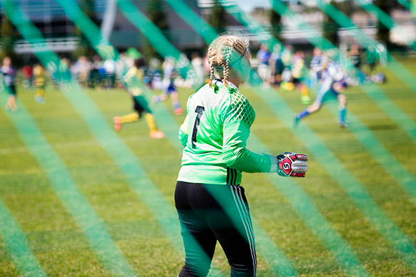 A female football goalkeeper pictured from behind. 