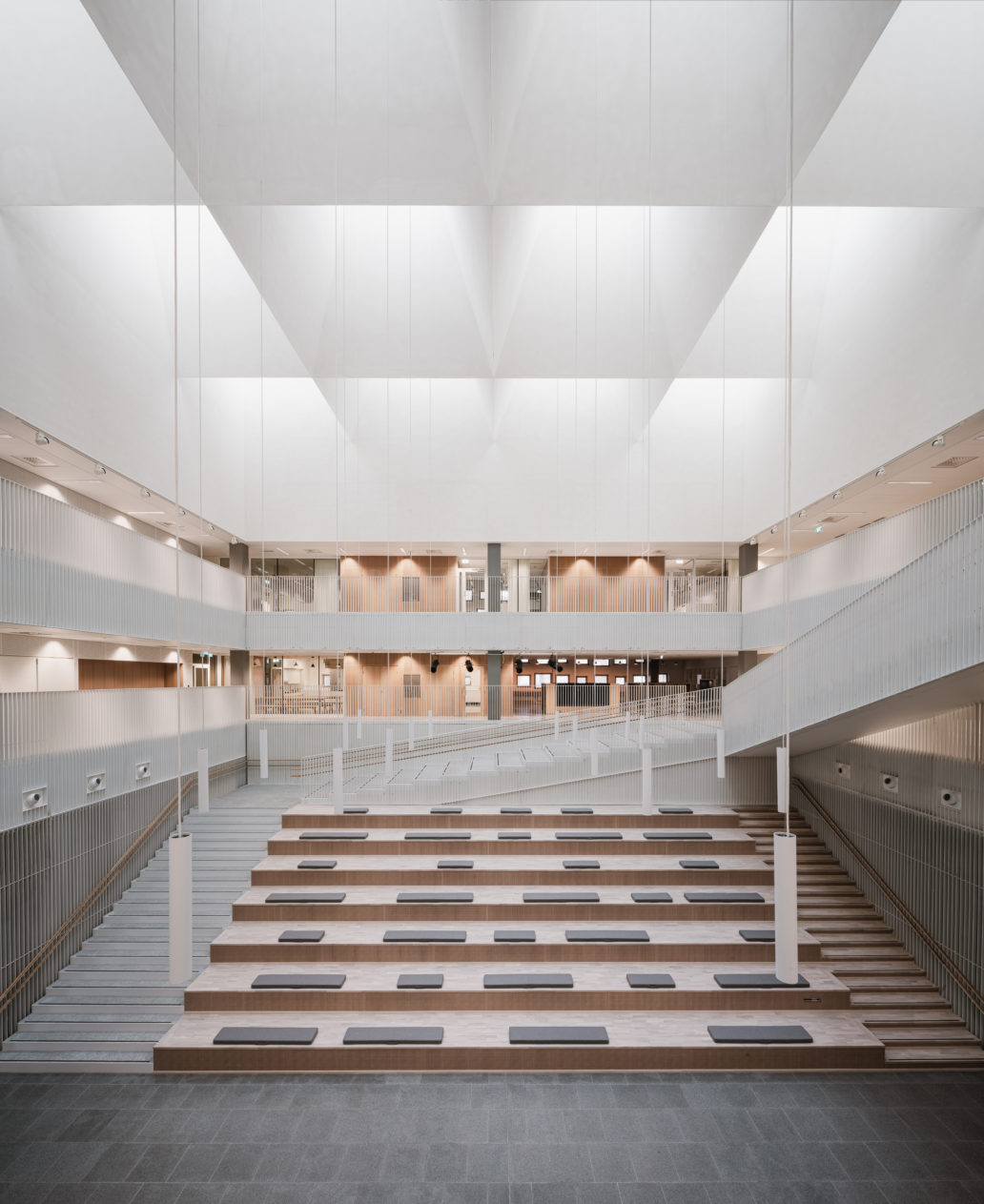 A white hall surrounded by staircases. 