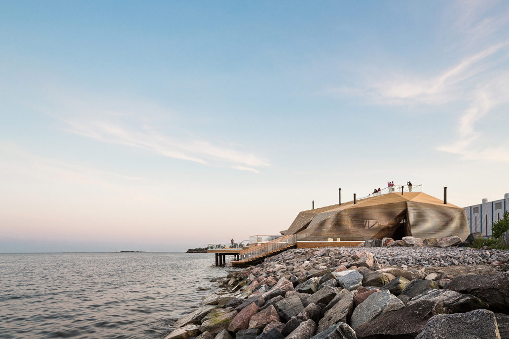 A wooden building next to the sea. 