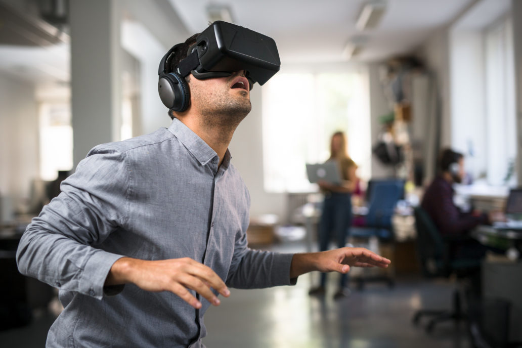 A man is wearing virtual reality glasses and looking up. 