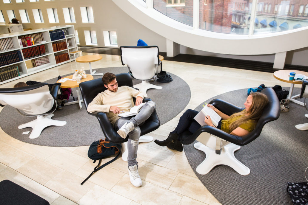 Two students sitting and reading in library.