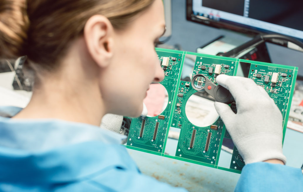 Technician soldering components to a PCB.
