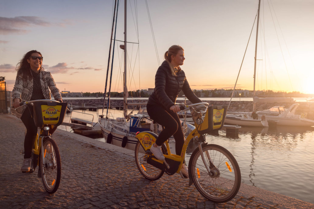 Women cycling at a harbor.