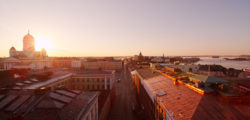 A silhouette of Helsinki rooftops in sunset, Helsinki cathedral in the background.