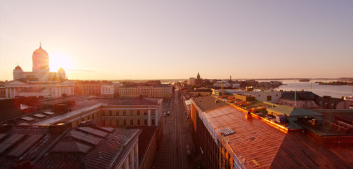 A silhouette of Helsinki rooftops in sunset, Helsinki cathedral in the background.